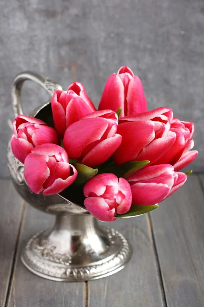 Boeket van roze tulpen in metalen vaas op houten achtergrond — Stockfoto