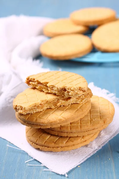 Stack of vanilla sandwich cookies on blue wooden background — Stock Photo, Image