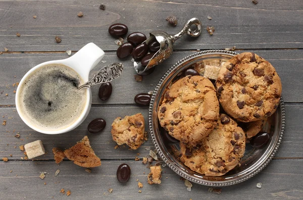 Verse zelfgemaakte chocoladeschilferkoekjes met kopje espresso op oude houten achtergrond — Stockfoto