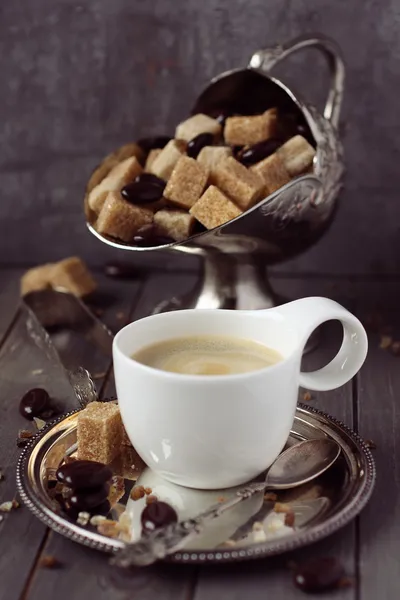 Xícara de café expresso, cubos de açúcar e doces de chocolate em fundo de madeira rústica — Fotografia de Stock