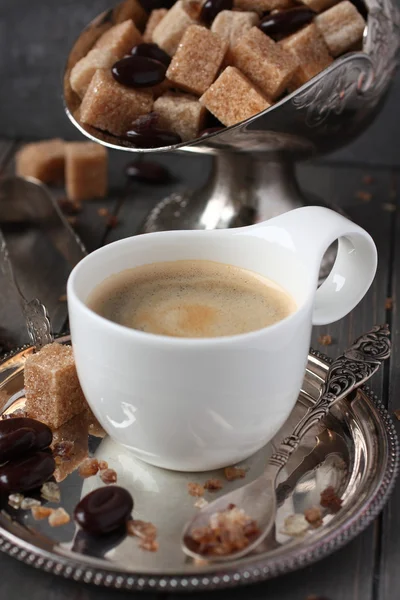 Xícara de café, cubos de açúcar e doces de chocolate no fundo de madeira velha — Fotografia de Stock