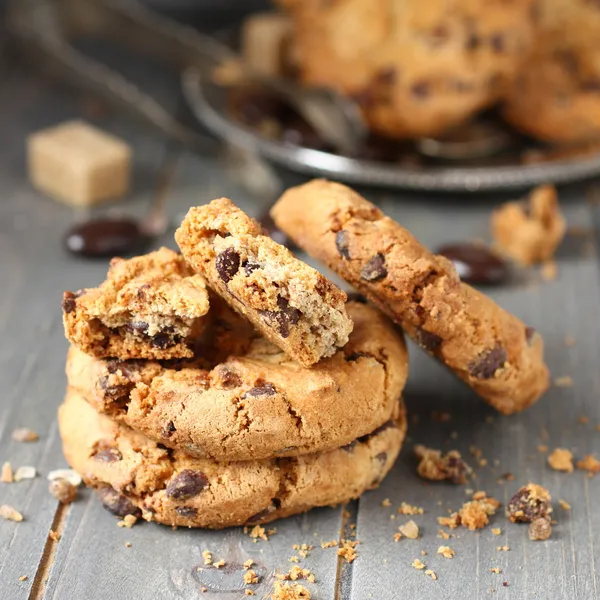 Halmozott csokoládé chip cookie-kat a rusztikus, fából készült háttér — Stock Fotó