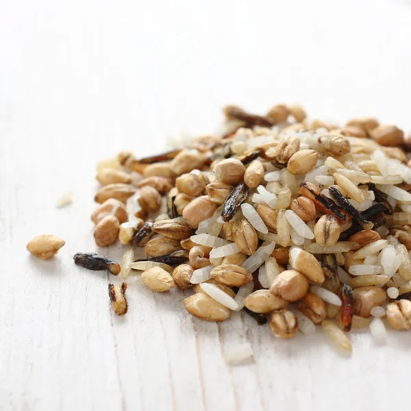 Pile of uncooked multigrain rice on white wooden background — Stock Photo, Image