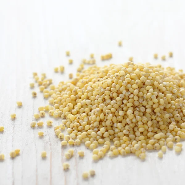 Heap of millet groats on white wooden background — Stock Photo, Image
