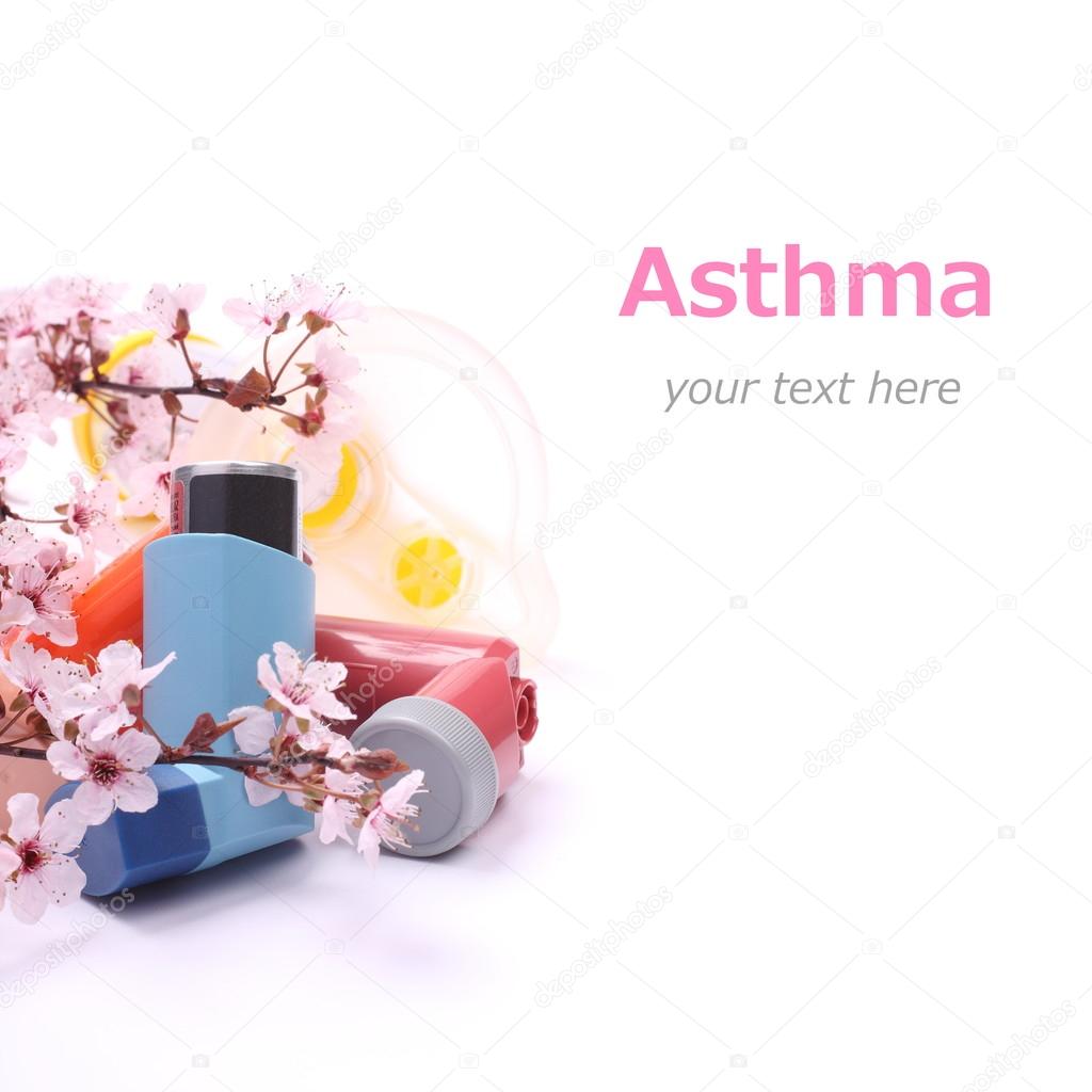 Asthma inhalers with extension tube for children and blossoming tree branches over white