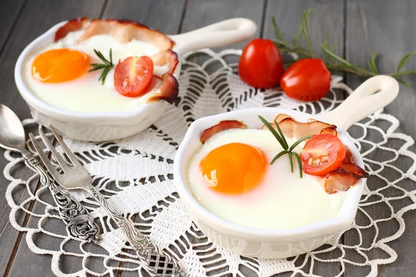 Jajko sadzone z boczkiem i pomidor w patelni ceramicznej — Zdjęcie stockowe