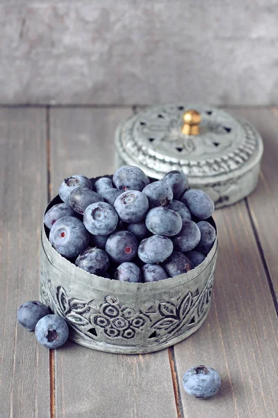 Fresh blueberries in small delicate metal casket on wooden background — Stock Photo, Image