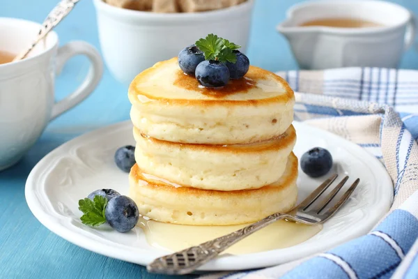 Ein Stapel Scotch-Pfannkuchen mit Honig und Blaubeeren auf dem Frühstückstisch — Stockfoto