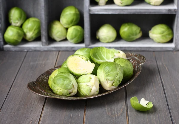 Fresh raw brussels sprouts in metal plate on  wooden background — Stock Photo, Image