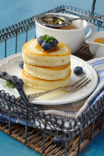 A stack of scotch pancakes with with honey and blueberries on tray — Stock Photo, Image