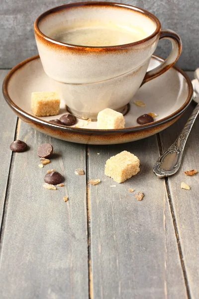 Xícara de café, cubos de açúcar e gotas de chocolate no fundo de madeira velha com espaço de cópia — Fotografia de Stock