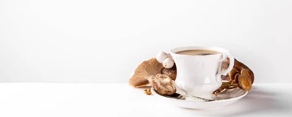 Mushroom coffee in white porcelain vintage cup over white background. New Superfood Trend. Copy space, selective focus. Banner