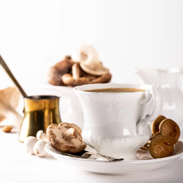 Mushroom coffee in white porcelain vintage cup over white background. New Superfood Trend. Copy space, selective focus.