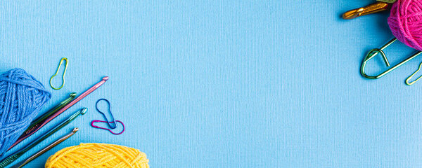 вязальный синий баннер с хлопчатобумажной пряжей, крючками и аксессуарами. Плоский накладной снимок с копировальным пространством