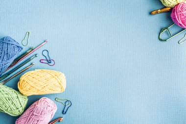Örgü arka planında çeşitli renkli iplikler ve örgü aksesuarları mavi, üst görünümde, düz yerde fotokopi alanı var. Retro biçimi