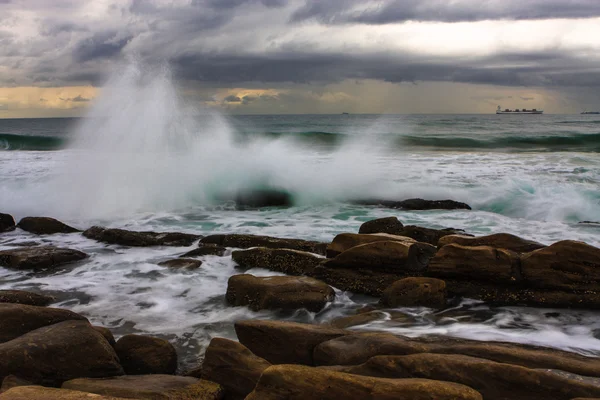 Große Welle plätschert auf Felsen — Stockfoto