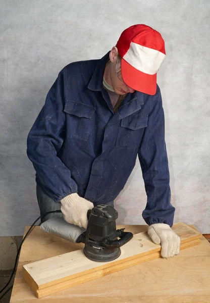 The worker polishes wooden board — Stock Photo, Image