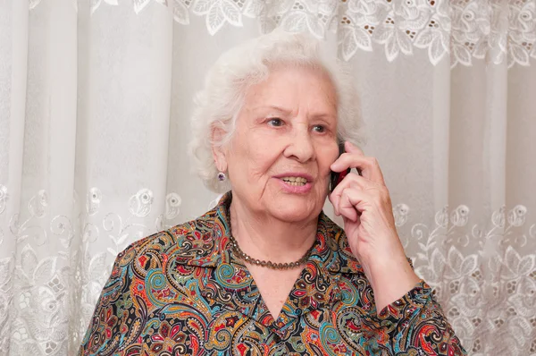 Senior woman speaks on the mobile phone — Stock Photo, Image