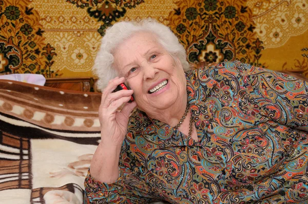 Senior woman speaks on the mobile phone — Stock Photo, Image