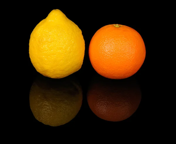 Sinaasappel en citroen op zwart — Stockfoto