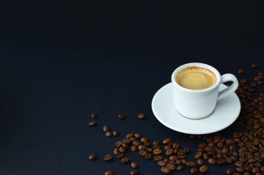 Siyah arka planda bir fincan sıcak kahve ve kızarmış kahve çekirdeği. Espresso, kahve kartı.