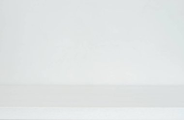 Beyaz ya da açık gri arka plan, tahta masa yüzeyi ve Venedik alçılı duvar. 