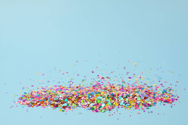 Красочные конфетти на голубом фоне. Предпосылки для дня рождения, Дня матери, Пасхи, вечеринки