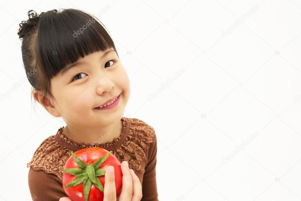 Cute asian kid with a tomato