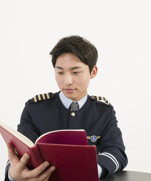 Airline pilot reading a book — Stock Photo, Image