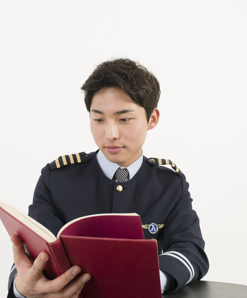 Airline pilot reading a book