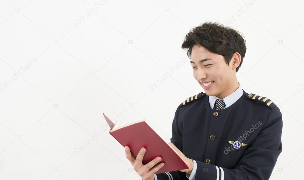 Airline pilot reading a book
