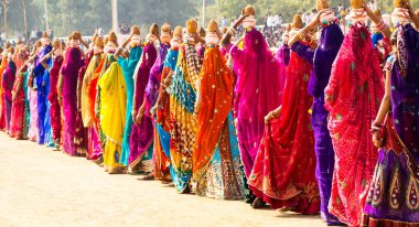 Hintli kadınlar Bikaner deve festivalinde su kabı ve hindistan cevizi taşıyor.