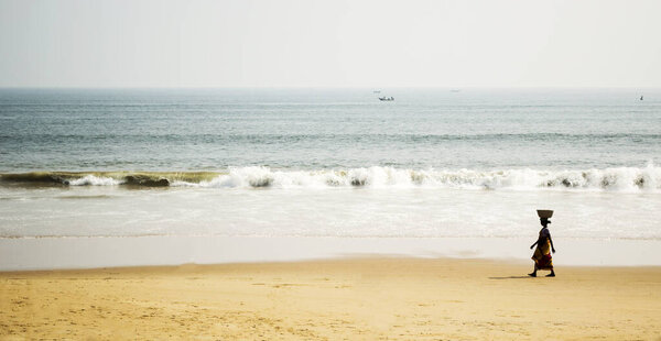 Woman carrying a basket on the beach