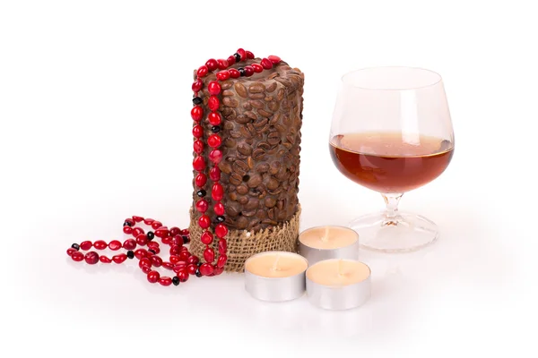 Candles, cognac, coral beads — Stock Photo, Image