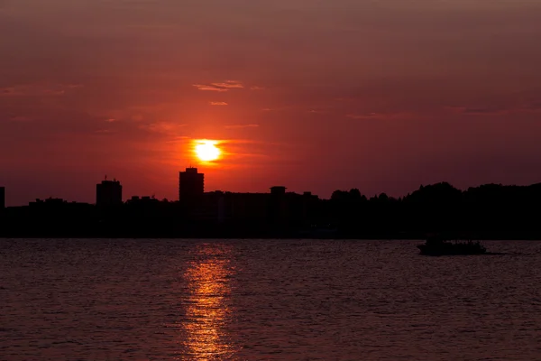 Sonnenuntergang über der Stadt am Meer — Stockfoto