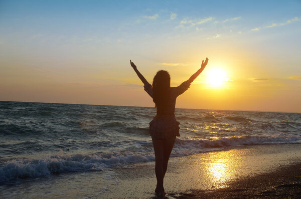 Girl admiring the sunset on the sea shore