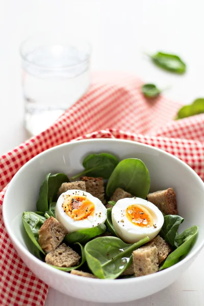 Salad with eggs, spinach and rye bread. — Stock Photo, Image