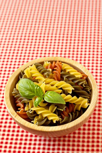 Mångfärgade pasta okokt med ett blad basilika — Stockfoto