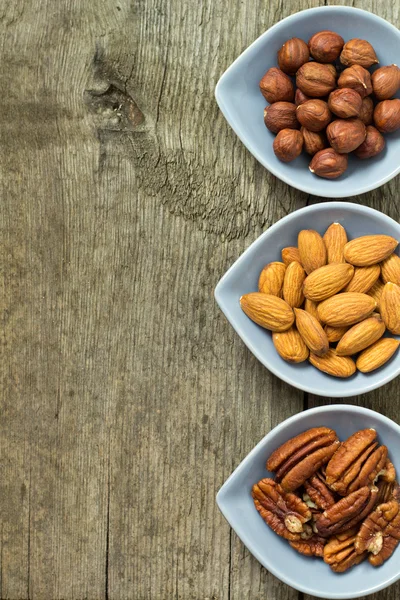 Миндаль, фундук и орехи орехи на деревянном фоне — стоковое фото