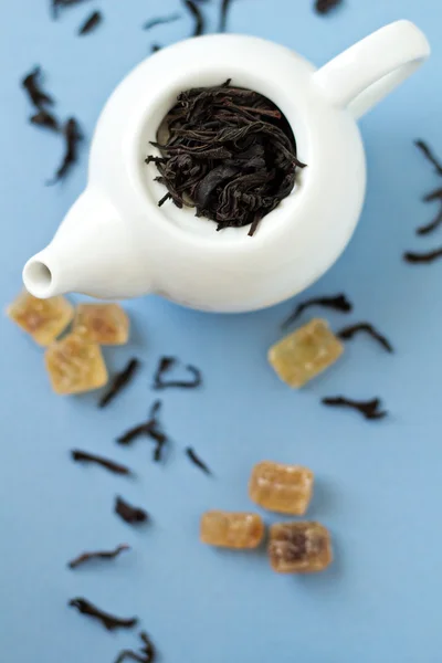 Small tea pot with leaves of black tea — Stock Photo, Image