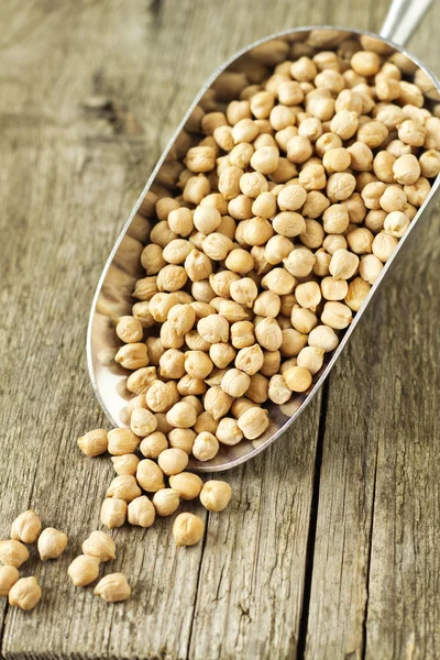 Raw chickpeas in a metal scoop — Stock Photo, Image