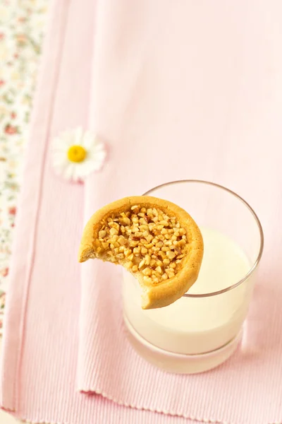 Cookie avec une bouchée prise sur un verre de lait — Photo