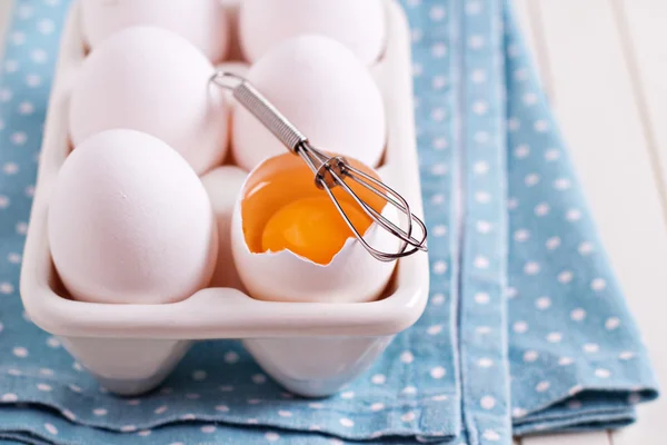 Шесть свежих яиц в яйцедержателе с одним разбитым яйцом — стоковое фото
