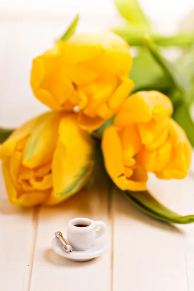 Kleine kopje koffie en gele tulpen — Stockfoto