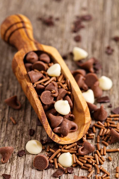 Chocolate drops and sprinkles in a wooden scoop — Stock Photo, Image
