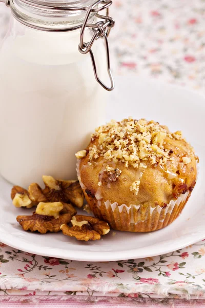 Banana muffin with walnuts and white chocolate and a bottle of milk — Stock Photo, Image