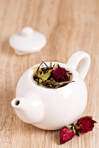 Chá verde com frutas, especiarias e pétalas de rosa em bule branco — Fotografia de Stock