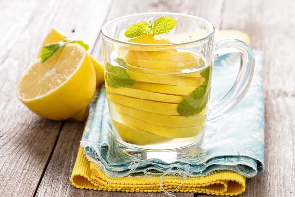 Tee mit Minze und ganzer Zitrone in einer transparenten Tasse — Stockfoto