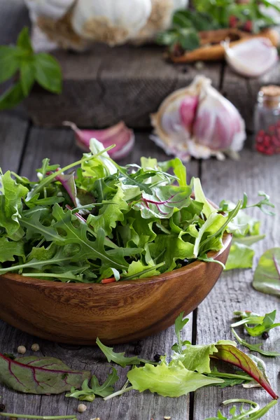 Salada verde deixa em uma tigela de madeira — Fotografia de Stock