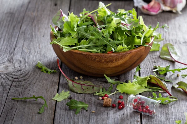 Green salad leaves in a wooden bowl — Stock Photo, Image